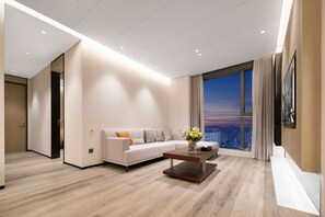 Een moderne woonkamer met een bank, salontafel en een groot raam met uitzicht op de stad.