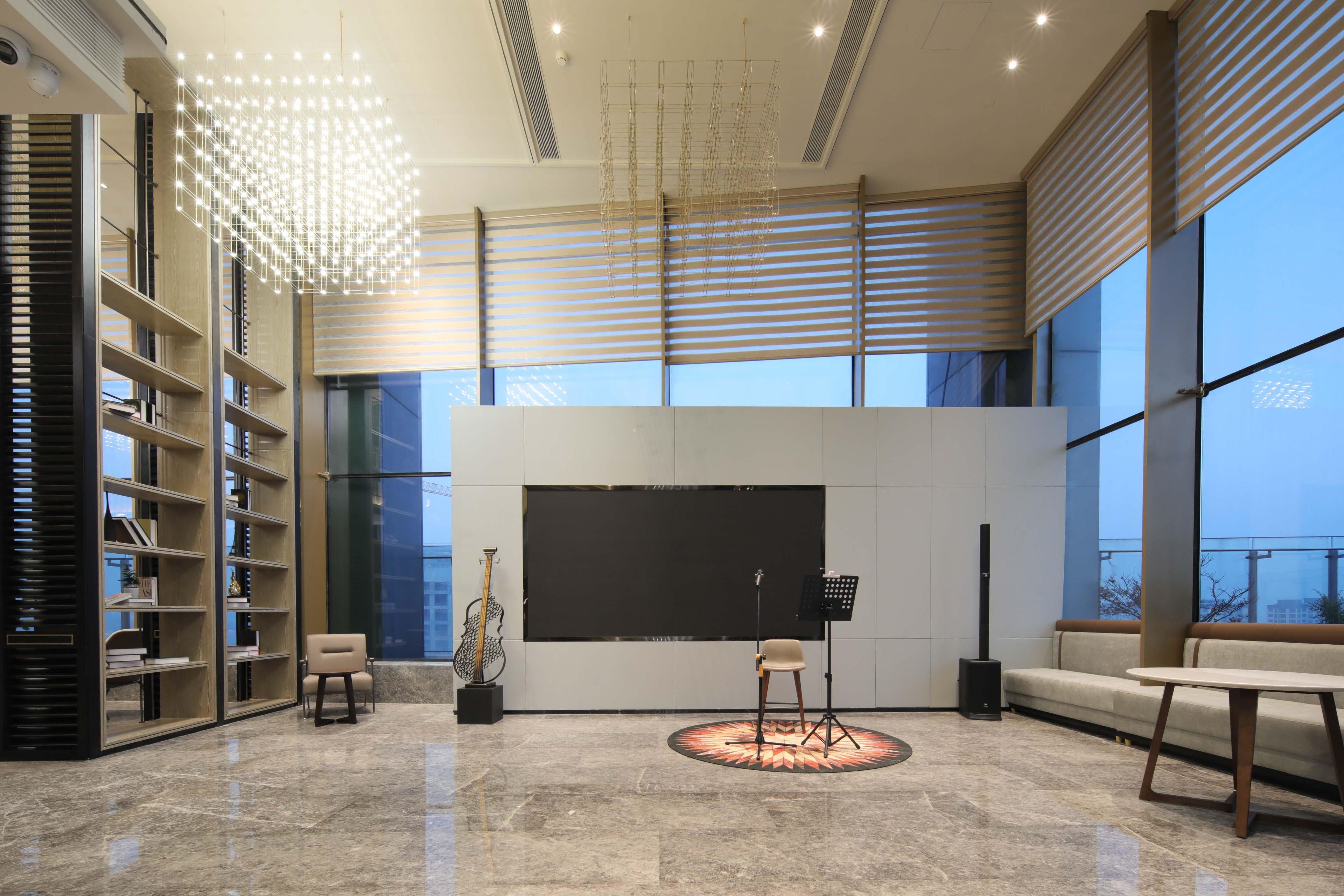 A spacious room with a large window, a piano, a sofa, and a bookshelf.