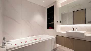 A modern bathroom with a freestanding bathtub, a vanity with a sink, and a large mirror.