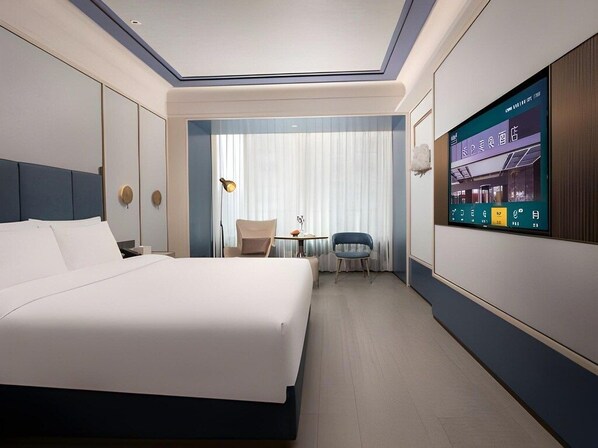 A modern hotel room with a large bed, a small table, a chair, and a TV displaying a restaurant menu. - Grand Madison Hotel Tangshan Caofeidian (Tangshan)