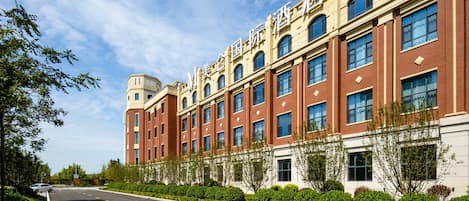 A multi-story building with a symmetrical facade, large windows, and a clear sky.