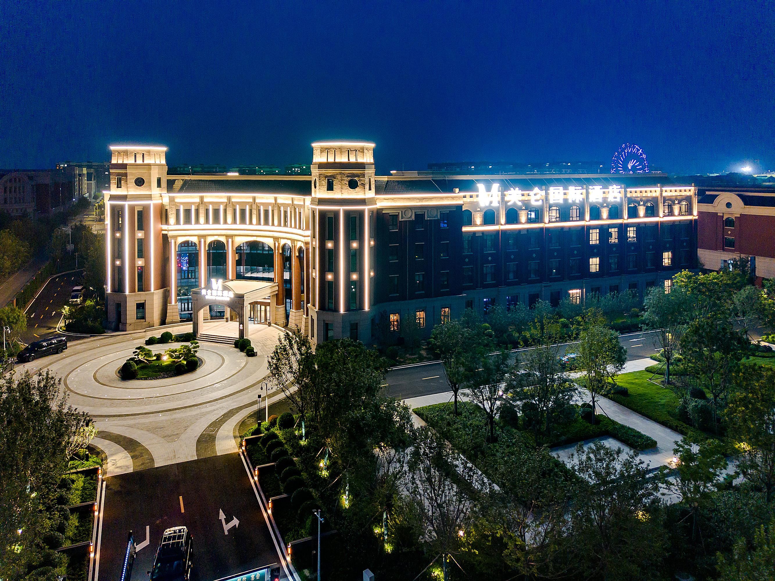 A large, modern hotel with a grand entrance, multiple floors, and a well-lit facade.