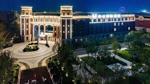 A large, modern hotel with a grand entrance, multiple floors, and a well-lit facade. - Grand Madison Hotel Tangshan Caofeidian (Tangshan)