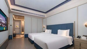 A modern hotel room with a large bed, a desk, and a television. - Grand Madison Hotel Tangshan Caofeidian (Tangshan)