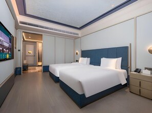 Een moderne hotelkamer met een groot bed, een bureau en een televisie.