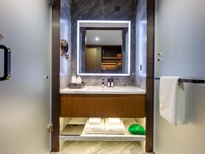 A modern bathroom with a marble vanity, a large mirror, and a towel rack. - Grand Madison Hotel Tangshan Caofeidian (Tangshan)
