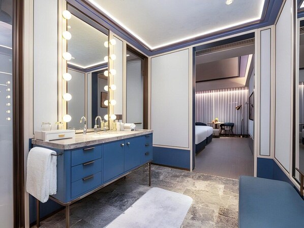 A modern hotel bathroom with a large mirror, vanity, and a bench. - Grand Madison Hotel Tangshan Caofeidian (Tangshan)