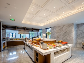 Un hall d’hôtel moderne avec un comptoir d’accueil en marbre, une grande fenêtre et un sol propre et ciré.