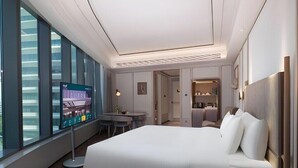 Une chambre d’hôtel moderne, dotée d’un grand lit, d’un bureau et d’une télévision.