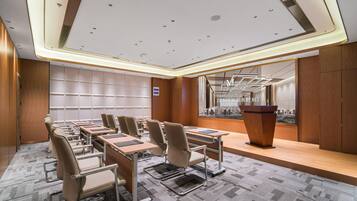 A conference room with a long table, chairs, a podium, and a cityscape view.