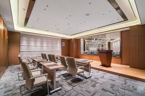 A conference room with a long table, chairs, a podium, and a cityscape view. - Grand Madison Hotel Nantong Tongzhou High-tech (Nantong)