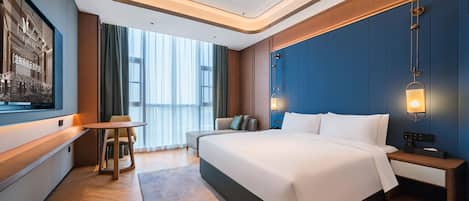 Una habitación de hotel moderna con una cama grande, un escritorio, una silla y vistas a la ciudad.