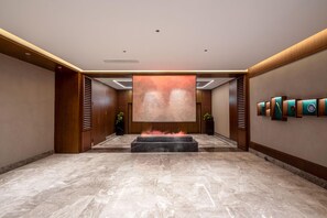 A spacious lobby with a marble floor, a large wall-mounted artwork, and a fire feature in the center. - Madison Hotel Hefei 2nd Affiliated Hospital (Hefei)
