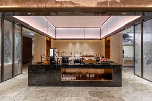 A modern coffee bar with a marble countertop, coffee machines, and a variety of coffee cups and pastries. - Madison Hotel Hefei 2nd Affiliated Hospital (Hefei)