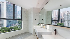 A modern bathroom with a large mirror, two sinks, and a view of a cityscape through large windows. - Madison Hotel Hefei 2nd Affiliated Hospital (Hefei)
