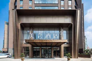A modern hotel entrance with a prominent sign, glass doors, and potted plants. - Madison Hotel Hefei 2nd Affiliated Hospital (Hefei)