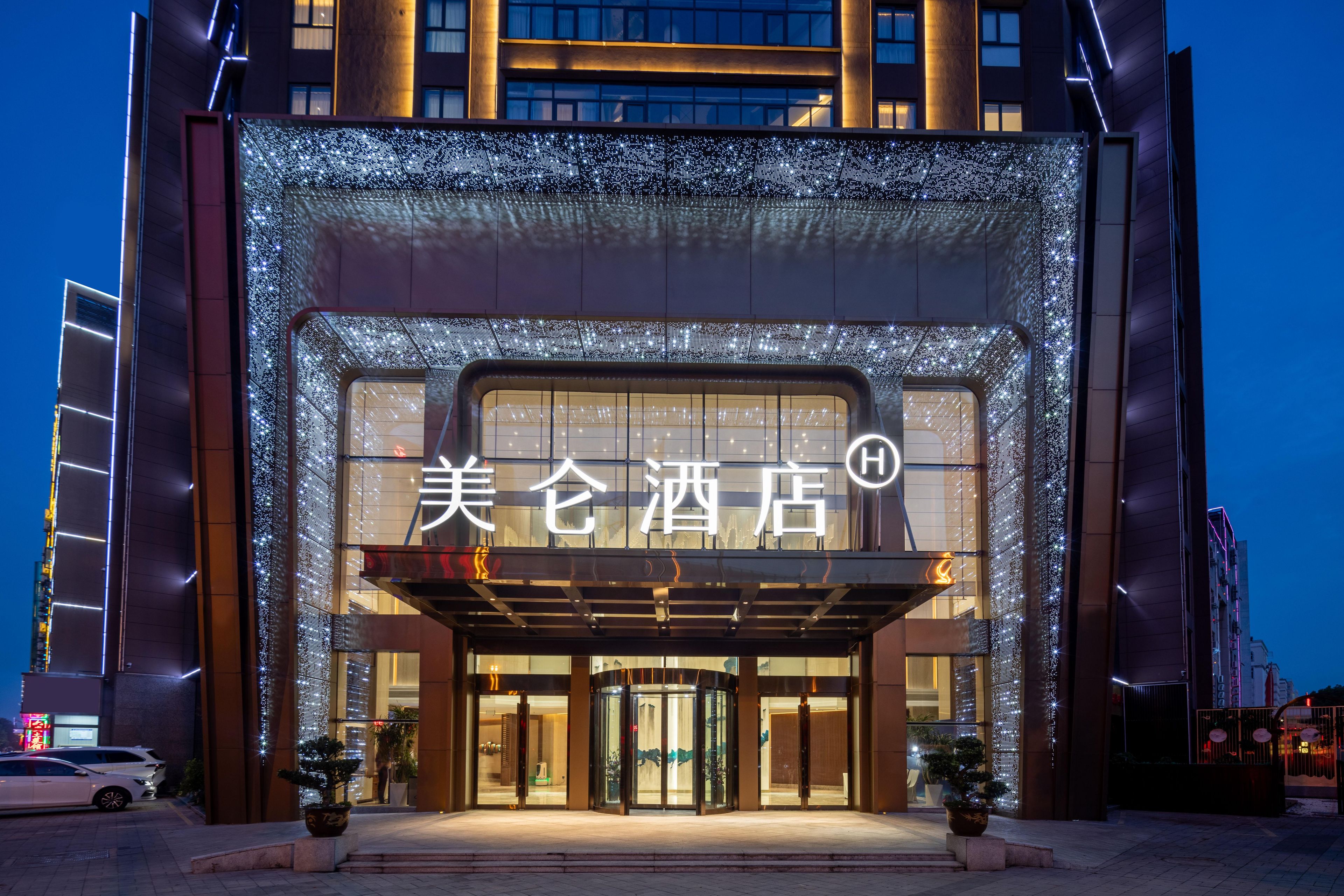 A hotel entrance with illuminated signage and a modern facade.