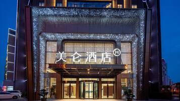 A hotel entrance with illuminated signage and a modern facade.