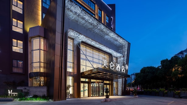 A modern hotel entrance with a glass facade and illuminated signage. - Madison Hotel Hefei 2nd Affiliated Hospital (Hefei)