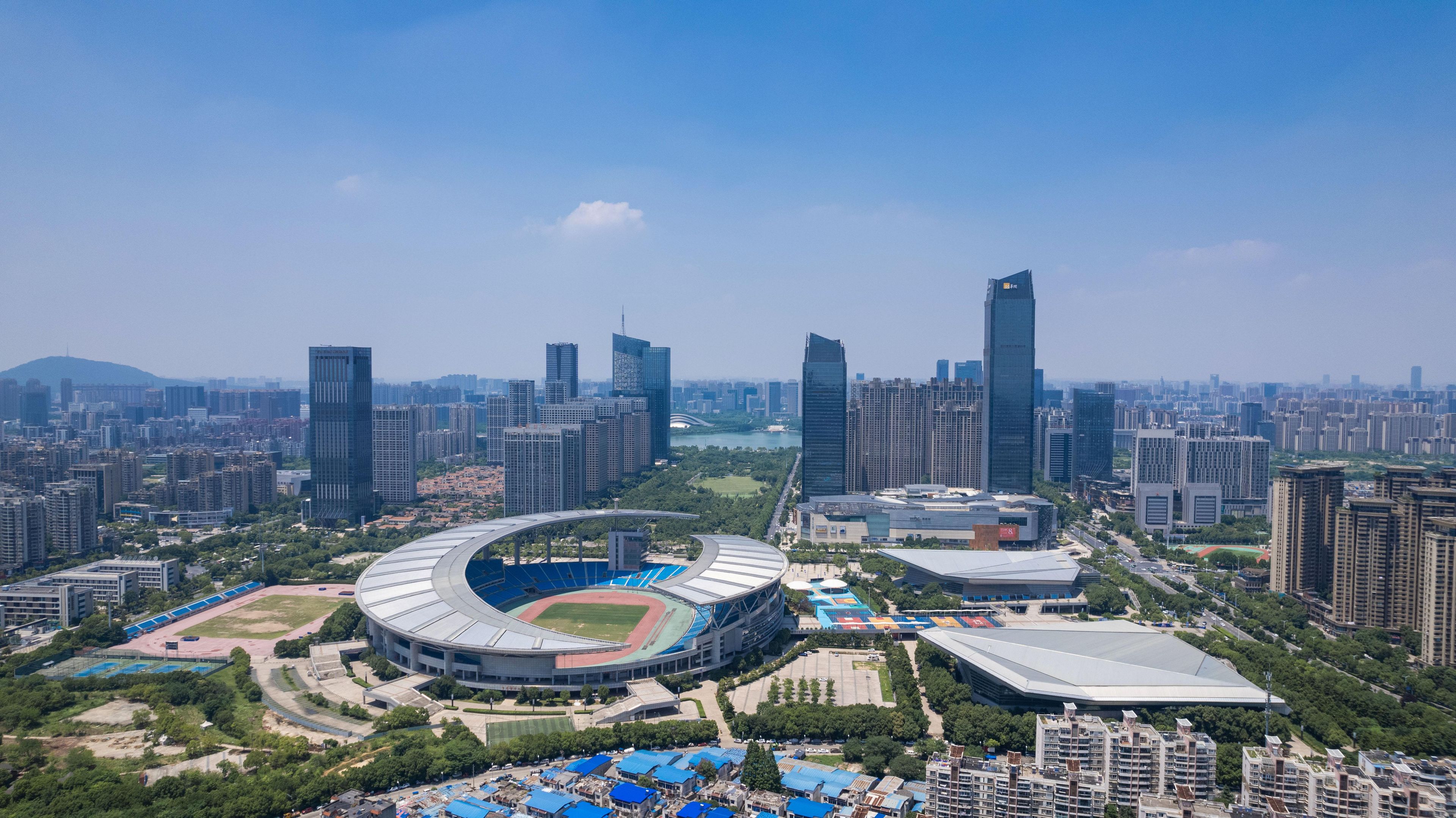 A stadium surrounded by high-rise buildings and a clear sky.