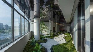 A modern building interior with large windows, a central pathway, and indoor plants. - Madison Hotel Hefei 2nd Affiliated Hospital (Hefei)