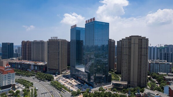 A high-rise building with a modern glass facade, surrounded by other high-rise buildings in an urban setting. - Madison Hotel Hefei 2nd Affiliated Hospital (Hefei)