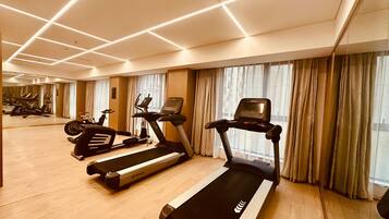 Un gimnasio moderno con cintas de correr, bicicletas estáticas y elípticas.