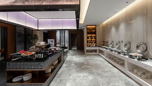 A modern hotel lobby with a buffet area, marble flooring, and a large wall-mounted artwork. - Madison Hotel Hefei 2nd Affiliated Hospital (Hefei)