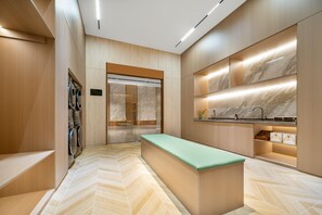 Una cocina moderna con piso de espiga, electrodomésticos integrados y salpicadero de mármol.