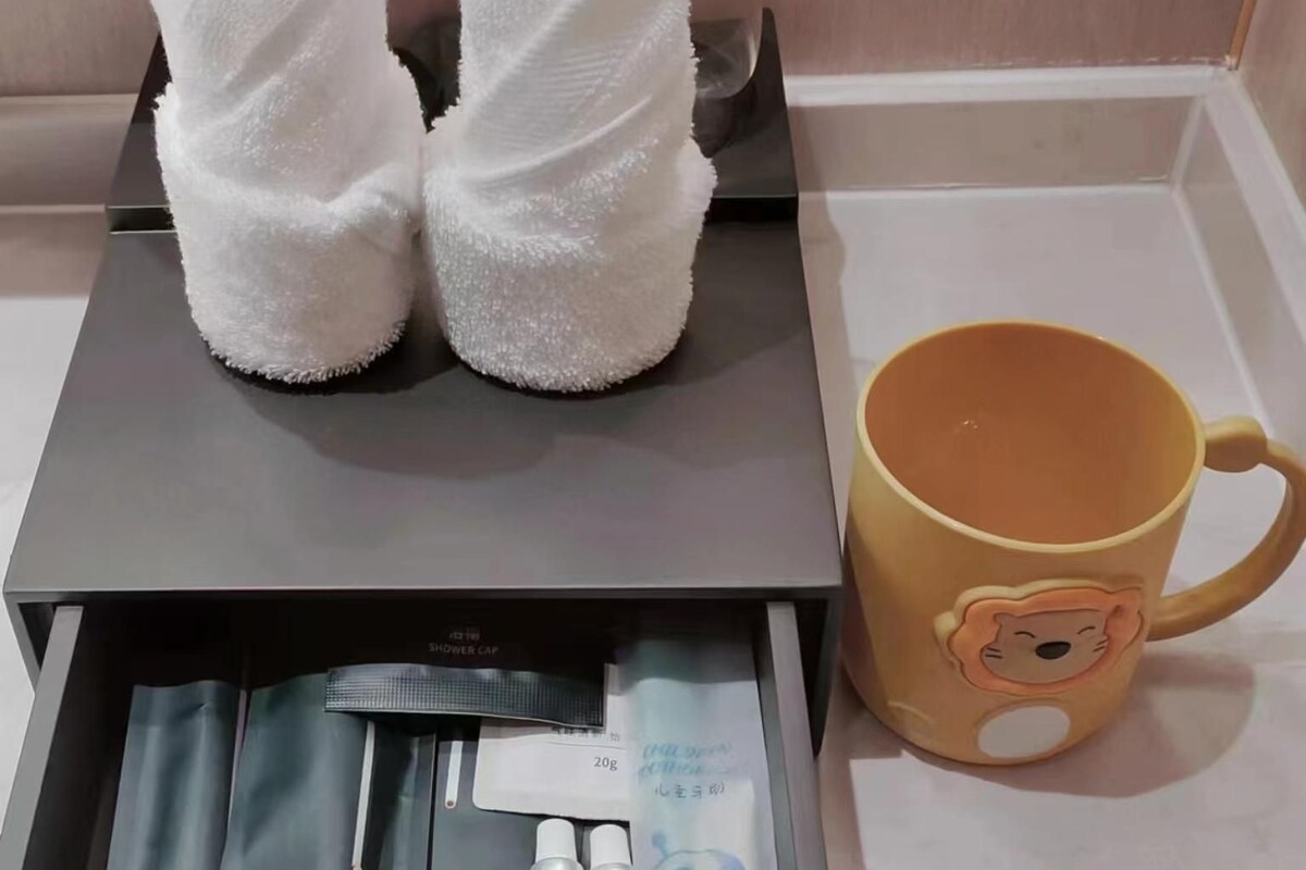 Un cajón con artículos de aseo personal, incluyendo un cepillo de dientes, pasta dental y un gorro de ducha.
