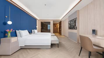 Habitación de hotel moderna con una cama grande, un escritorio y vistas al pasillo.