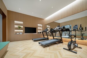 Un gimnasio moderno con cintas de correr, elíptica y bicicleta estática.