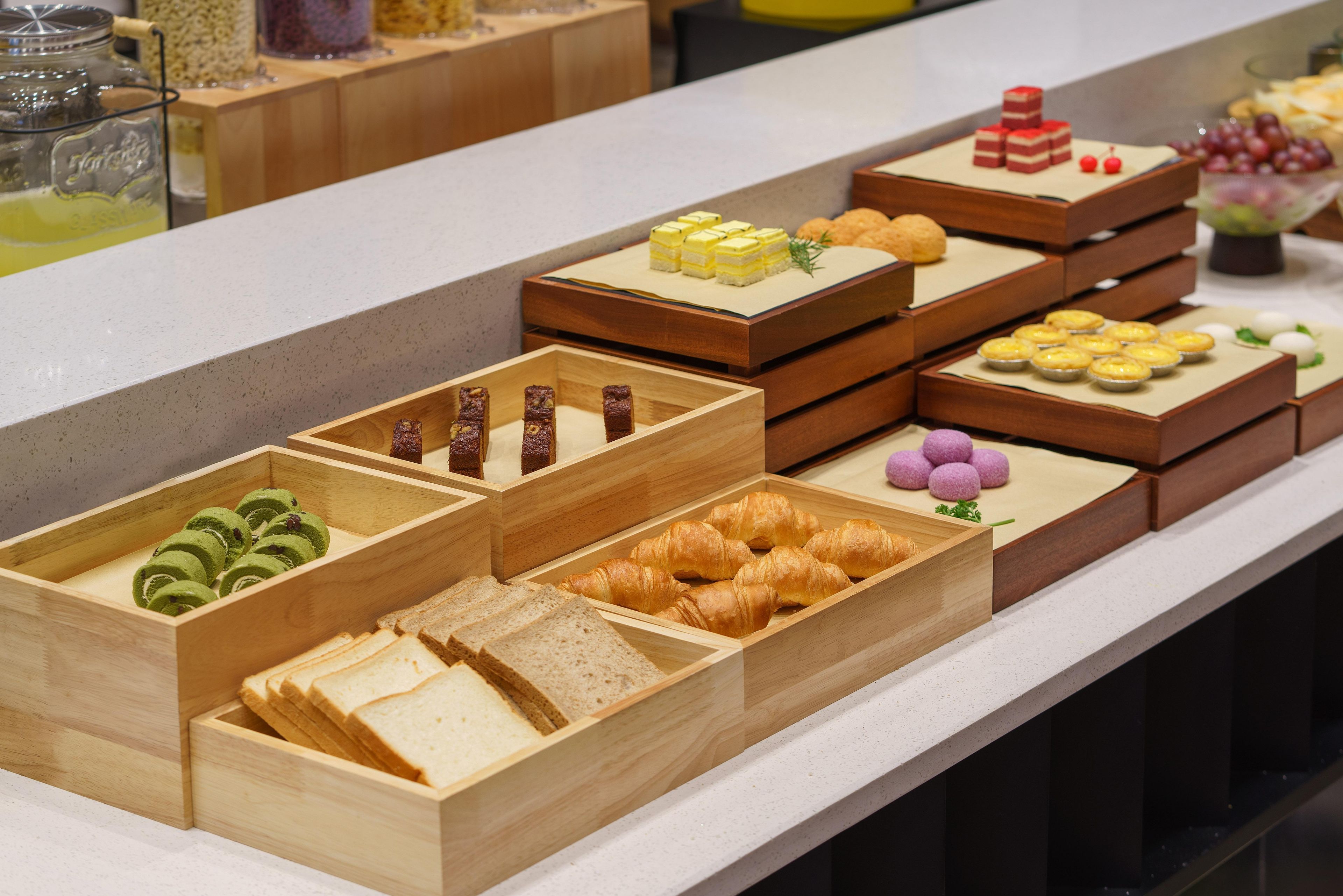 Un bufé con diversos alimentos, incluyendo pasteles, sándwiches y postres.