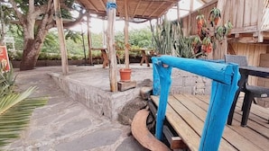 An outdoor patio area with a wooden deck, a blue railing, and potted plants. - Cabañas Don Jorge (Puerto Baquerizo Moreno)