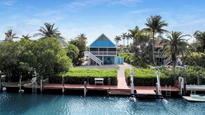 Een resort met een zwembad, een blauw gebouw en palmbomen.