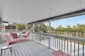 Relax on the spacious deck with a serene view of the surrounding greenery and water.