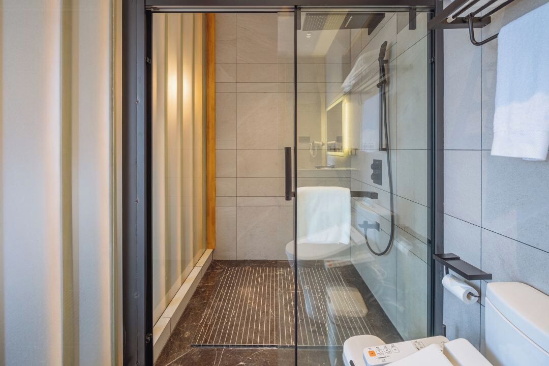 Une salle de bain moderne avec une douche à parois de verre, des toilettes et un lavabo.