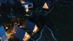 An aerial view of a residential area with multiple houses, some with lit windows indicating occupancy. - Yichun Old Yu Xinzhi Homestay (Yichun)
