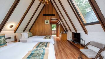 Acogedor dormitorio en el ático con dos camas, televisión y techo de madera.