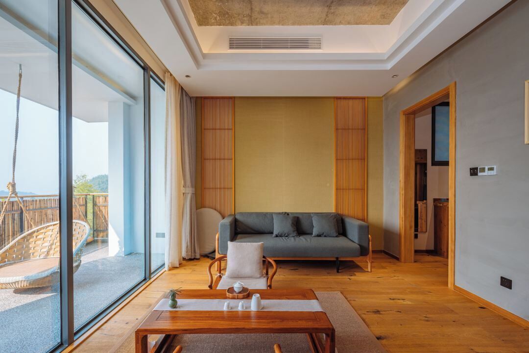 A modern living room with a sofa, a wooden coffee table, and a view of a balcony.
