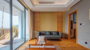 A modern living room with a sofa, a wooden coffee table, and a view of a balcony.