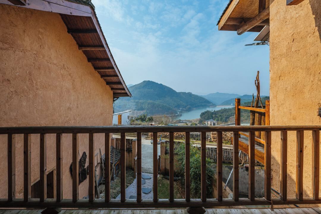 A balcony with a view of a river and mountains.