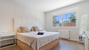 Une chambre à coucher avec un lit, une table de chevet, un radiateur et une fenêtre.