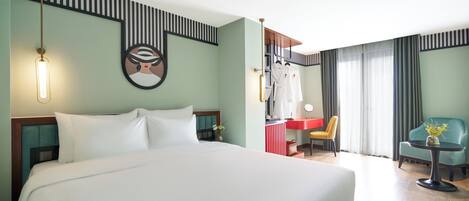 A hotel room with a large bed, a desk with a chair, a mirror, and a window with curtains.