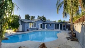 A residential swimming pool with a house in the background. - Relax in Clovis and Enjoy The Stay (Clovis)