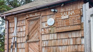 A wooden building with a sign indicating a ski waxing room and a sauna. - Gooseberry Trailside Suites | Lester River Suite (Two Harbors)