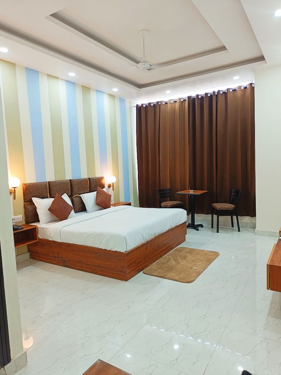 A bedroom with a large bed, a desk, and a chair.