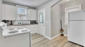 Une cuisine moderne avec des armoires blanches, une cuisinière, un four à micro-ondes et un réfrigérateur.