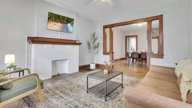 Un salon avec une cheminée, un coin repas et un grand miroir.