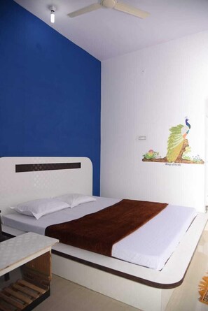 Une chambre à coucher avec un lit, un bureau et un ventilateur de plafond.
